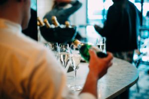 Waiter pouring champagne in glass.